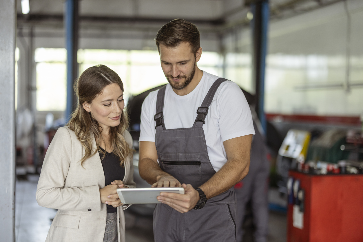 Car Mechanic and Customer Using Digital Tablet