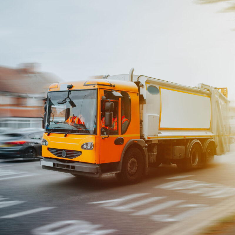 Garbage truck driving in urban environment in United Kingdom