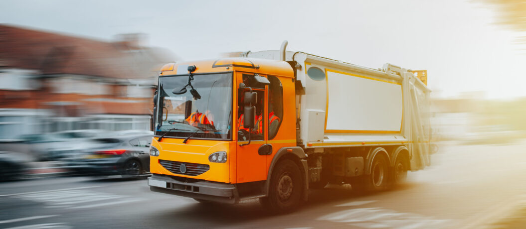 Garbage truck driving in urban environment in United Kingdom