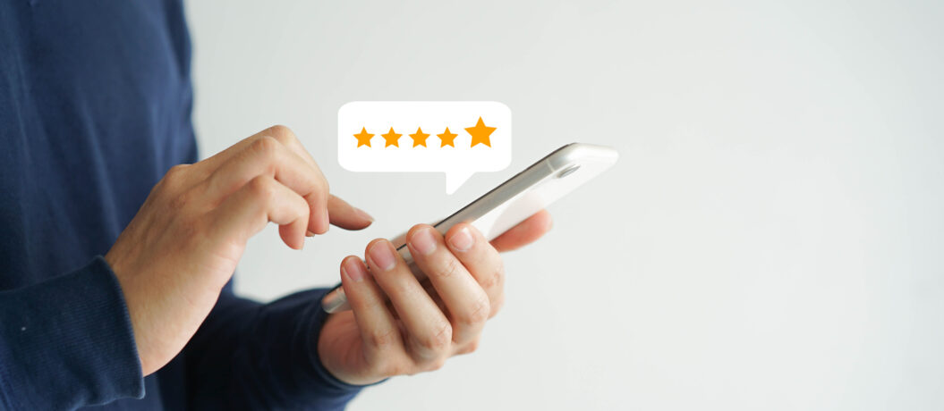 close up on customer man hand pressing on smartphone screen with  five star rating feedback icon and press level good rank for giving best score point to review the service , technology business concept
