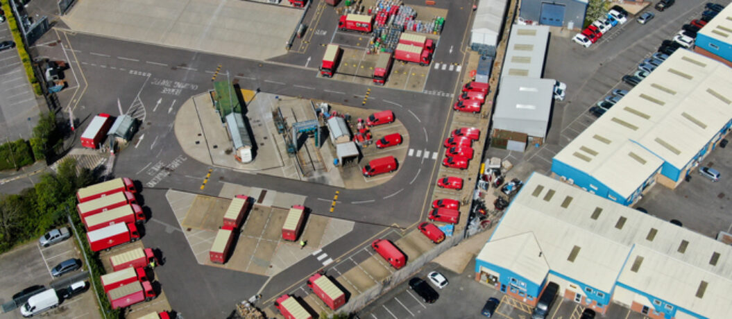 Drones eye view looking down on a Royal mail postal sorting depot in England showing lorries and vans being loaded