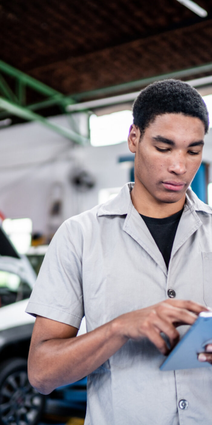 Auto mechanic man using a digital tablet on the repair shop