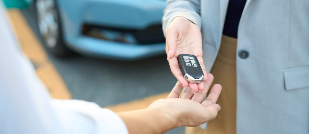 Woman handing over car keys outside